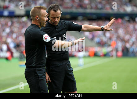 Arbitro Stuart Attwell (destra) parla con per guardafili prima di aggiudicare la pena per il West Ham United durante il match di Premier League a Londra Stadium. Foto Stock