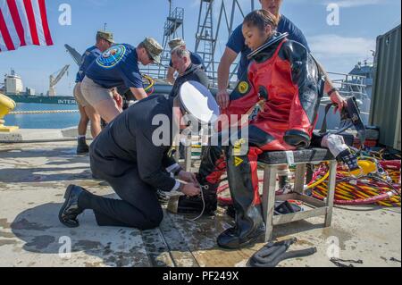 160226-N-HD porta670-001 HUENEME, California (Feb. 26, 2015) - capo meccanico di costruzione Elisia Correa, assegnato alla Naval Facilities Engineering Command, ingegneria e Expeditionary Warfare Center, rimuove il suo dry suit dopo la sua ultima ufficiale dive come Seabee subacqueo, per chiedere il permesso di scendere a terra per l'ultima volta durante la sua cerimonia di pensionamento. Correa in pensione dopo 23 anni di servizio come un Seabee e un subacqueo Seabee. (U.S. Navy foto di Utilitiesman 3rd Class Stephen Sisler/rilasciato) Foto Stock