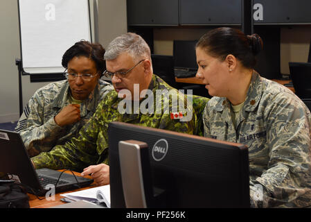 Master Chief Sgt. Tori Hill, 108 Medical Group, Arctic caso NCOIC, sinistra, il Mag. Jean Chevalier, 41 CF salute Centro Servizi, forze armate canadesi, centro e il Mag. Lisa Haik, 919th Special Operations Medical Squadron, Arctic Care AOIC coordinare il movimento di entrambe le truppe e le forniture per l'Artico a cura di esercitare presso la riserva di esercito 99th sostegno regionale il comando delle attrezzature del sito di concentrazione 99 magazzino in base comuneGuire-Dix Mc-Lakehurst, N.J., nel febbraio 25, 2016. Membri del New Jersey Air National Guard 108th dell ala, riserva marina, Air Force si riserva, esercito della riserva 99th ECS e 3° Me Foto Stock