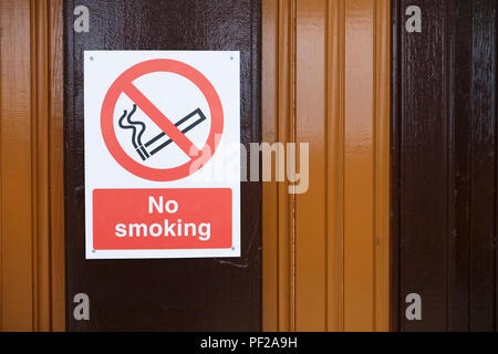 Vietato fumare e logo sul legno scuro parete del pannello Foto Stock