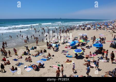 Spiaggia affollata durante una ondata di caldo in Huntington Beach California Foto Stock