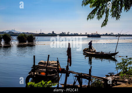 Panoramica vista di acqua con il pescatore di ottenere le sue reti pronti e una barca e le isole in lontananza. Foregound ha alcuni grezzi dock e forniture in barca. Foto Stock