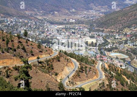 Avvolgimento o curvata asfaltata sulla collina con vista della città di Thimphu, Bhutan Foto Stock