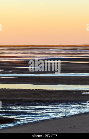 Bassa marea sulla spiaggia al tramonto Foto Stock