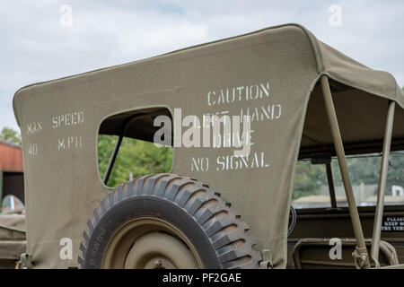 Vista posteriore di un'iconica jeep dell'esercito americano della seconda guerra mondiale che mostra il cofano rialzato di questo veicolo militare restaurato. Le informazioni sono stampate sul retro del cofano. Foto Stock