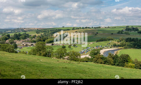 Costa del Burnsall: Pretty riverside village, Burnsall, diventa un hotspot turistico per i locali che vogliono rinfrescarsi e godere di un mare senza sentire il Foto Stock