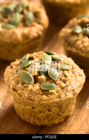 Freschi Fatti in casa in legno di noce di zucca muffin ai fiocchi d'avena con pepita di semi di zucca in alto sul piatto di legno (messa a fuoco selettiva) Foto Stock