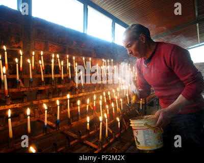 Un devoto circondato in vapore accendendo candele per la Vergine di Cocharcas nella chiesa di Sapallanga in Huancayo città peruviana Ande Centrali Foto Stock