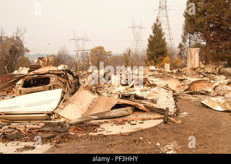 Home rasa al suolo, porta di garage allacciata e la posa di un heap dopo la recente wild fire fire storm in Redding, CA. Fumo e cenere in aria come Foto Stock