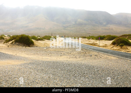 Vista del vuoto strada asfaltata nel deserto di Lanzarote, Isole Canarie Foto Stock