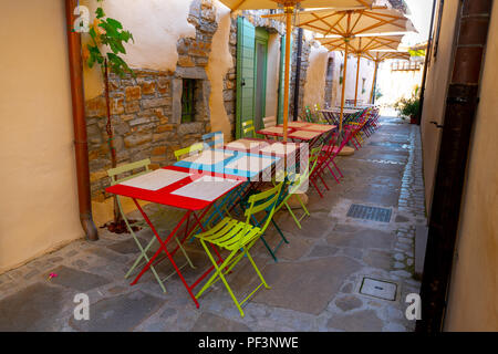 Piccoli caffe, ristorante nella strada stretta in una città medievale con colorati tavoli e sedie Foto Stock