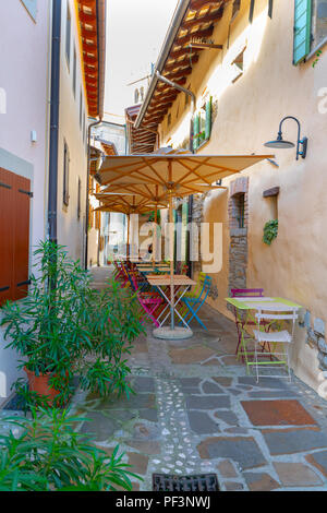 Piccoli caffe, ristorante nella strada stretta in una città medievale con colorati tavoli e sedie Foto Stock