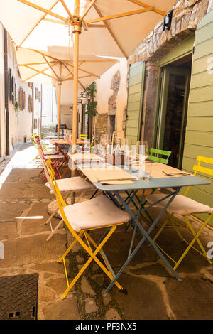 Piccoli caffe, ristorante nella strada stretta in una città medievale con colorati tavoli e sedie Foto Stock