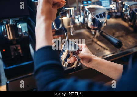 Voce maschile barista prepara la bevanda sulla macchina per caffè nella caffetteria. Professional espresso preparato da barman Foto Stock