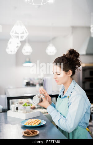 Cameriera la preparazione di ordine in Cafe Foto Stock