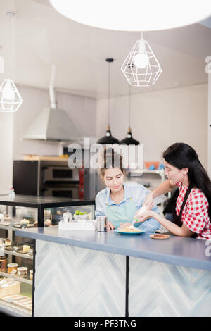 Le donne che lavorano nel negozio di dolci Foto Stock