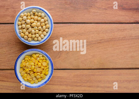 Vista dall'alto di semi di soia e sbucciate i fagioli di soia in un recipiente su un tavolo di legno con copia spazio. Sana e nutrition food concept,concetto di cucina a vista. Foto Stock