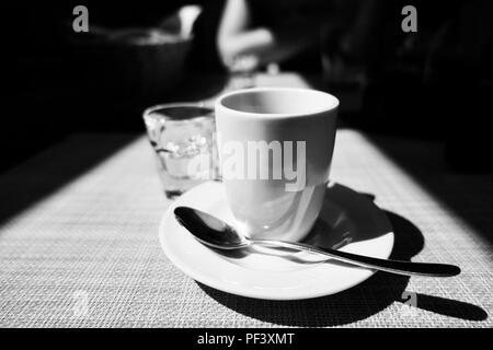 Caffe corretto, tradizionale bevanda italiana con caffè espresso e un colpo di liquore, solitamente la grappa, bianco e nero, drammatico fulmine Foto Stock