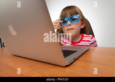 Bambino con gli occhiali tramite il computer Foto Stock