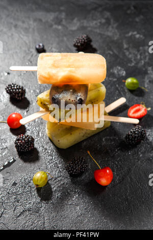 Foto in alto di frutta congelata di ghiaccio su ogni altro e bacche Foto Stock