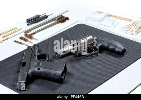Un revolver e una pistola la posa su un tampone in preparazione per la pulizia Foto Stock