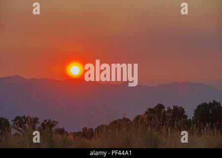 Smoky tramonto sulla Sierra Nevada causati dal fumo dai leoni incendio in California Foto Stock