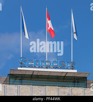 Zurigo, Svizzera - 27 Settembre 2017: la parte superiore di un edificio recanti il segno della Schroders azienda e bandiere di Zurigo e la Svizzera. Schr Foto Stock