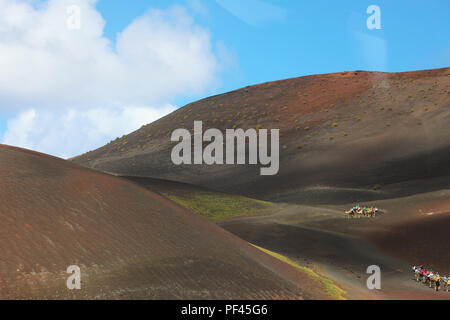 LANZAROTE, Spagna - 20 Aprile 2018: l'incredibile paesaggio desertico del Parco Nazionale di Timanfaya con rosso e nero sabbie di montagna con cielo blu e di Pentecoste Foto Stock