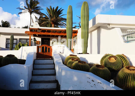 Bianco casa moderna con vegetazione di cactus in Lanzarote, Spagna. La vacanza estiva, destinazione di viaggio, affitto casa concetti. Foto Stock