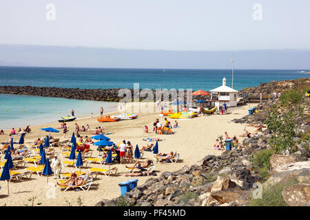 LANZAROTE, Spagna - 18 Aprile 2018: bagnanti in Playa Dorada una spiaggia a sud dell'isola di Lanzarote, Isole Canarie Foto Stock