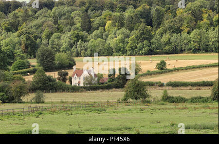 Un inglese un paesaggio rurale nella Chiltern Hills con balle di fieno e boschi e lone house Foto Stock