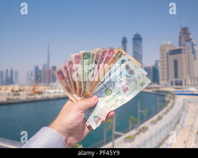 Un uomo tiene il denaro degli Emirati Arabi Uniti. Dirham. Foto Stock