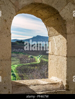 Entroterra siciliano paesaggio visto attraverso una vecchia finestra di pietre Foto Stock