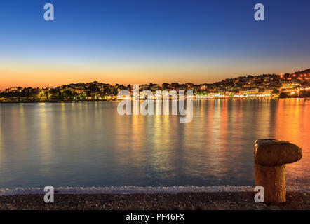 Incredibile Neos Marmaras cityscape e porto ora d'oro vista al tramonto dal dock con bollard in primo piano Foto Stock