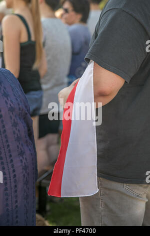 Uomo con il bianco e il rosso bandiera polacca in mano. La celebrazione dell anniversario dell'Insurrezione di Varsavia. Simboli polacca. Foto Stock