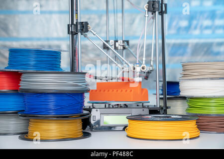 ABS e PLA filament accanto alla stampante 3D. Bobine di plastica Foto Stock