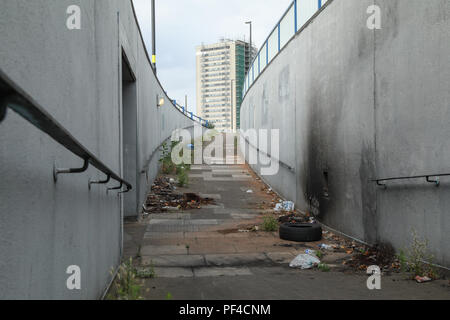 Un trascurato sottopassaggio pedonale situato in all interno della città di Birmingham, UK. Il sentiero è ricoperta da vegetazione e inquinata con lettiera. Foto Stock