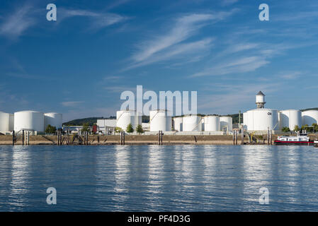 Silos di stoccaggio,deposito di carburante di petrolio e benzina sulle rive del fiume in Germania occidentale su un bel cielo blu con nuvole. Visibile tanker ba Foto Stock