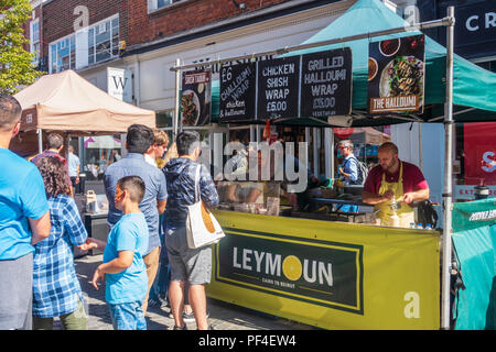 La gente in coda per acquistare cibo a un cibo stallo a una strada del mercato di Peascod Street in Windsor, Regno Unito. Foto Stock