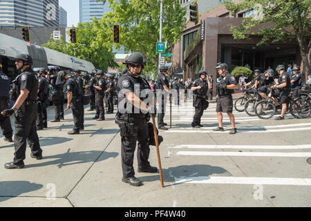 Seattle, WA, Stati Uniti d'America. Il 18 agosto, 2018. Gli ufficiali di polizia fissare la strada in cui destra e sinistra i manifestanti sono di fronte al fuori Seattle City Hall. Credito: Maria S./Alamy Live News. Foto Stock