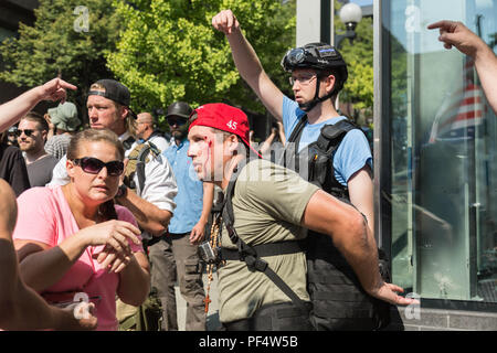 Seattle, WA, Stati Uniti d'America. Il 18 agosto, 2018. Una pistola pro sostenitore di essere ferito da un oggetto sconosciuto dove pistola pro e contro i sostenitori della pistola rivolta verso off. Credito: Maria S./Alamy Live News. Foto Stock