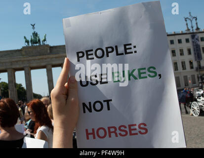 Berlino, Germania. 19 Ago, 2018. Un animale attivista per i diritti contiene un segno di protesta di fronte alla Porta di Brandeburgo. Circa una cinquantina di attivisti per i diritti degli animali di manifestare contro l'uso di carrozze trainate da cavalli a Berlino. La dimostrazione è stata auspicata dal gruppo di azione di "Fair Play", che funziona contro lo sfruttamento degli animali. Credito: Paolo Zinken/dpa/Alamy Live News Foto Stock