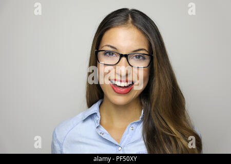 Bella Donna sorridente in occhiali guardando la telecamera su sfondo grigio. Close up felice giovane donna multi gara indossando occhiali da vista che mostra toothy Foto Stock