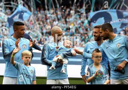 Manchester City David Silva (centro) al passo con il suo neonato figlio Mateo all inizio del match di Premier League al Etihad Stadium e Manchester. Foto Stock