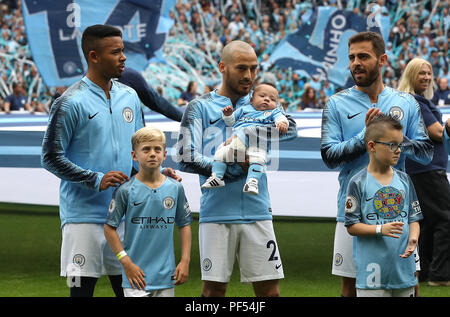 Manchester City David Silva (centro) al passo con il suo neonato figlio Mateo all inizio del match di Premier League al Etihad Stadium e Manchester. Foto Stock