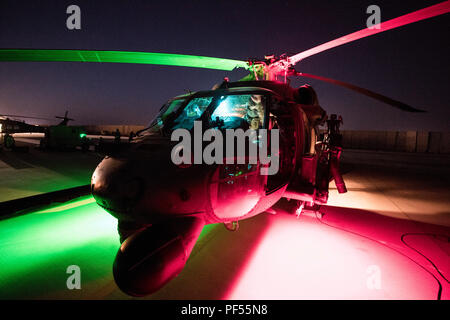 Un U.S. Air Force HH-60G Pavehawk assegnato alla quarantaseiesima salvataggio Expeditionary Squadron (ERQS) siede sulla linea di volo come equipaggio membri pre volo dell'aeromobile prima di una missione in una località segreta, Iraq, a sostegno di funzionamento inerenti risolvere il Agosto 8, 2018. La 46th ERQS fornisce combattere la ricerca e le funzionalità di salvataggio in tutta la regione a sostegno di funzionamento inerenti a risolvere. In collaborazione con le forze di partner, Combined Joint Task Force - Funzionamento inerenti risolvere sconfitte ISIS in determinate aree dell'Iraq e Siria e stabilisce le condizioni per proseguire su operazioni di aumento regionali stabili Foto Stock