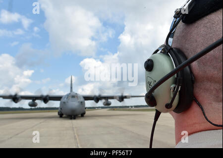 Il personale Sgt. Benjamin Stover, 821st risposta di emergenza squadrone di supporto capo equipaggio, esegue il marshalling di un C-130H Hercules aeromobili, durante l'esercizio sciopero del Nord a temoli Army Airfield, Mich il Agosto 9. Sciopero del Nord è una solida preparazione militare esercizio coordinato dall'esercito del Michigan Guardia Nazionale quali funzioni congiunte e multi-nazionale le forze armate di lavorare insieme per la forza totale integrazione. (U.S. Air Force foto di Tech. Sgt. Liliana Moreno) Foto Stock