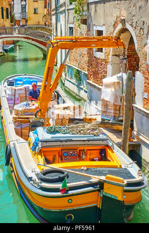 Venezia, Italia - 15 Giugno 2018: lo scarico di merci mediante la gru da trasporto in barca Venezia Foto Stock