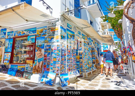 Mykonos, Grecia - 22 Aprile 2018: strada stretta nella città di Mykonos con un negozio di souvenir e la gente a piedi Foto Stock