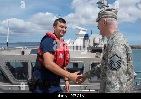 Stati Uniti Air Force Master Sgt. James Healey, primo sergente assegnato all'Molokai clinic team, grazie un membro dell'U.S. Coast Guard per mettendo in salamoia forniture per Tropic Care Maui County 2018, Molokai, Hawaii 14 agosto 2018. Tropic Care Maui County 2018 è una joint-servizio, "hands-on" disponibilità missione di formazione offrendo nessun costo di personale medico, dentistico e vision servizi alle persone in sei posizioni in tutta Maui Molokai e Lanai da Agosto 11-19. (U.S. Air National Guard photo by Staff Sgt. Lonnie Wiram) Foto Stock